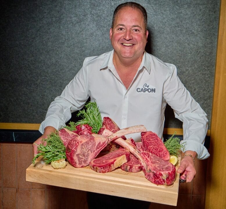 Chef Josh Capon holding steaks at Capon's Chophouse Hackensack, New Jersey