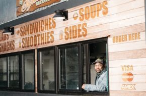 Damon Pennington stands at the window inside his shipping container–turned–eatery.