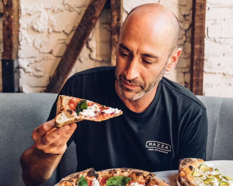 Dan Razza, owner of Razza in Jersey City, prepares to bite into a slice