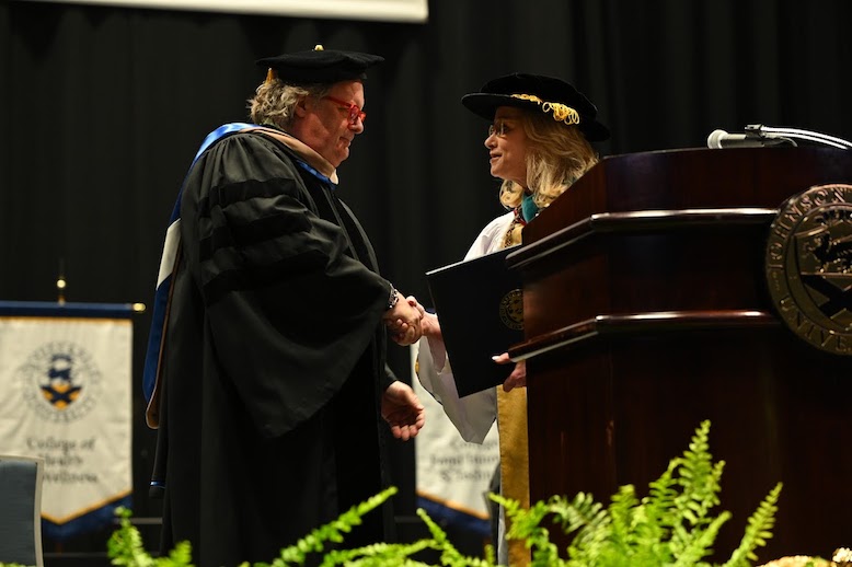 David Burke shakes hands with Chancellor Mim Runey at Johnson & Wales' commencement.