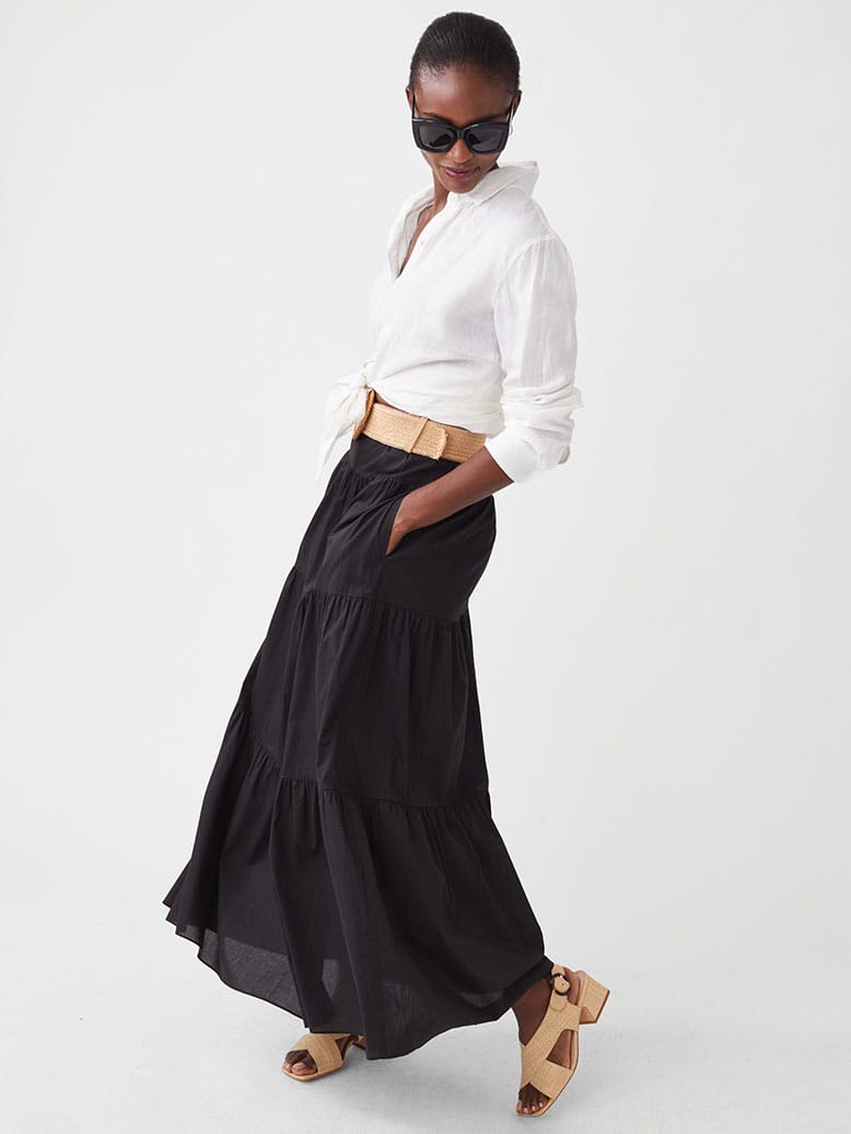 Woman in white button-down and long black flowy skirt