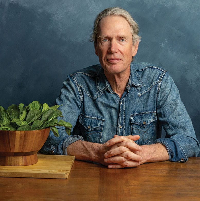 Author John Seabrook next to a bowl of spinach