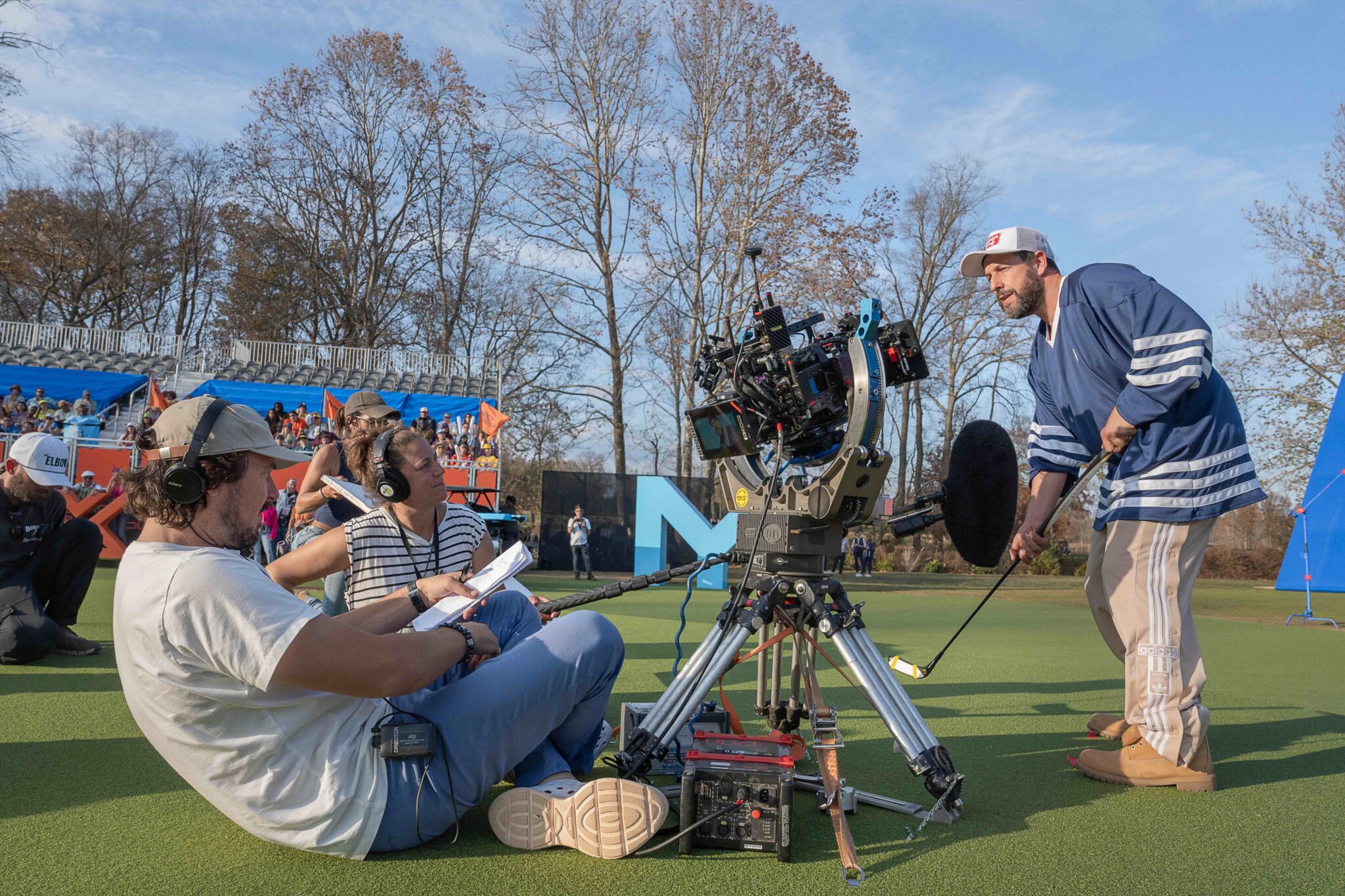 Adam Sandler poses with a golf club filming a "Happy Gilmore 2" scene with director Kyle Newacheck