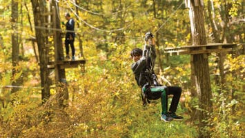 Boy on zip-lining course at TreEscape Aerial Adventure Park in Vernon Township, New Jersey