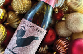 Bottle of wine amid Christmas ornaments