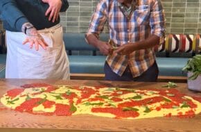 Celebrity chefs Christian Petroni and Marcus Samuelsson dressing polenta on a tabletop at Marcus Live! at the American Dream mall in East Rutherford, New Jersey