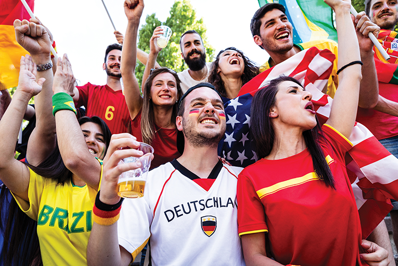 Soccer fans drinking and cheering at game