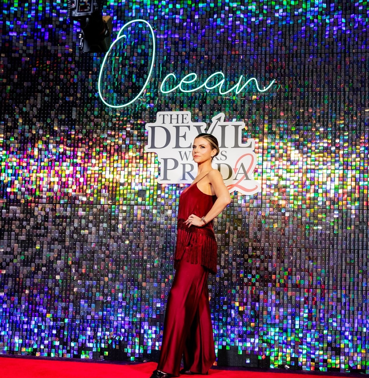 Image of a woman in front of a glittering sign for 'The Devil Wears Prada 2' at Ocean Resort Casino in Atlantic City, NJ