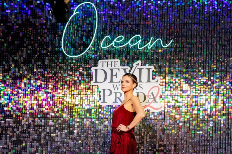 Image of a woman in front of a glittering sign for 'The Devil Wears Prada 2' at Ocean Resort Casino in Atlantic City, NJ