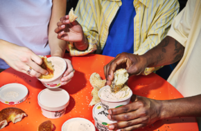 People dipping PopUp bagels in cream cheese