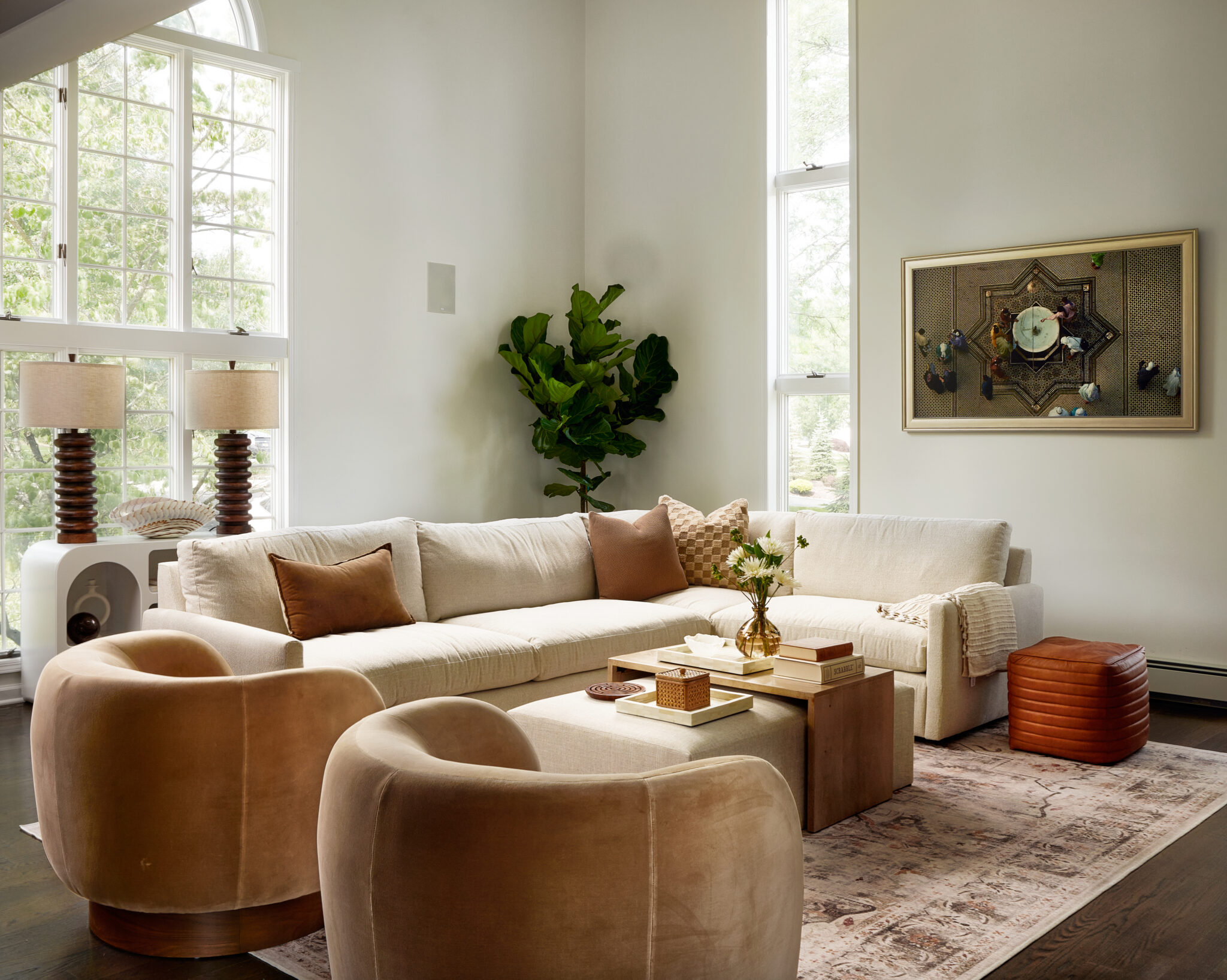 Inside a colonial home in Randolph, NJ, a clean-lined sofa pairs with curvy velvet swivel chairs—both upholstered in high-performance fabric that withstands family life—creating a relaxed yet refined mood in a calming, neutral palette. 