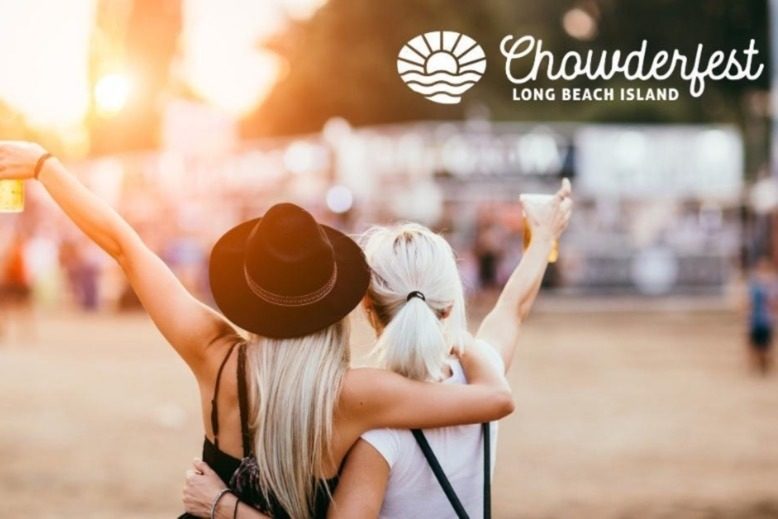 Two women holding beer and embracing each other at an outdoor festival