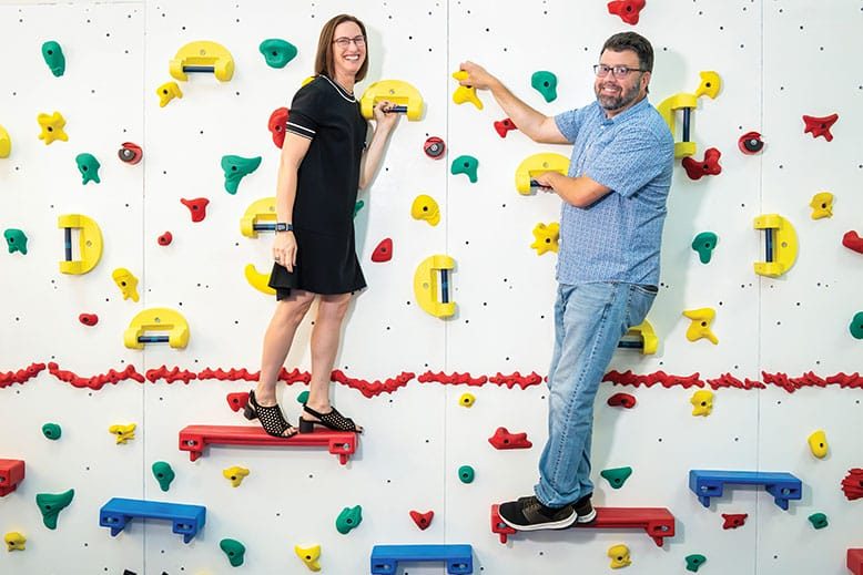 Sharon Sevrens on a climbing wall with physical therapist Scott Matthews at his West Caldwell nonprofit, Intensive Therapeutics