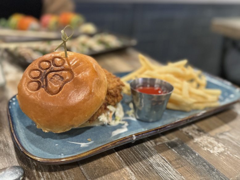 A fried chicken sandwich with a pawprint-stamped bun at Copper Dog in Wildwood