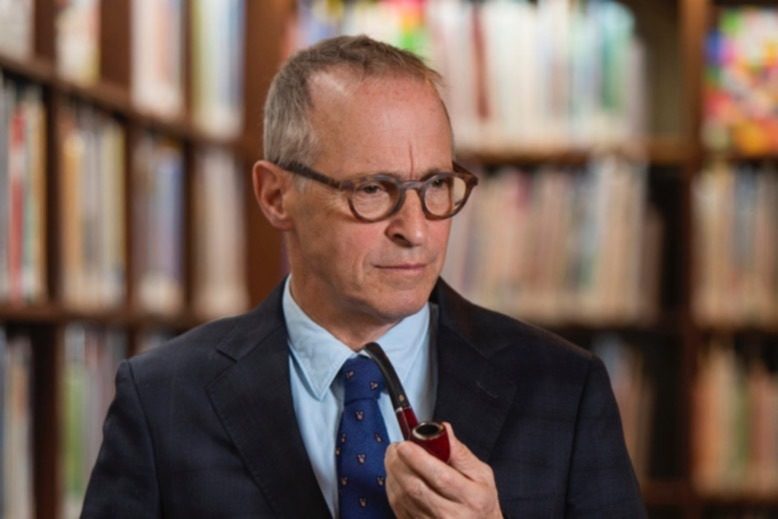 Humor writer David Sedaris holding a pipe.