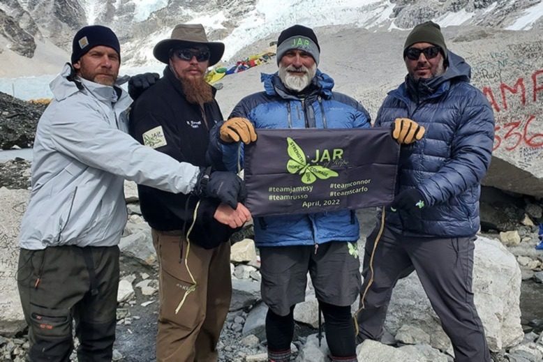 Jim Raffone and three other climbers hold a JAR of Hope banner on Mt. Everest