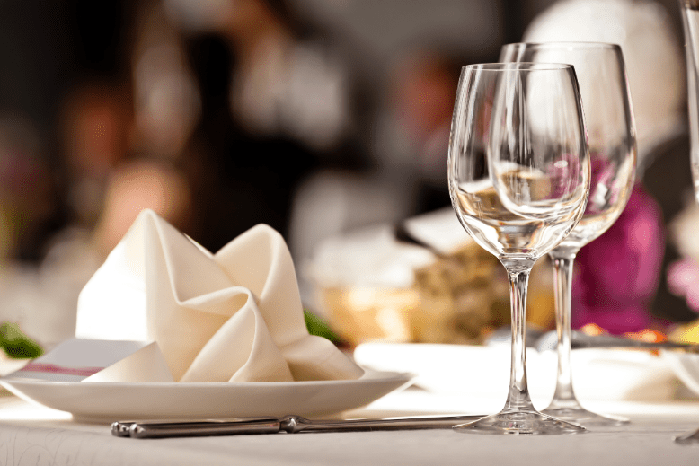 Wine glasses, plate and white napkin on a restaurant tabletop