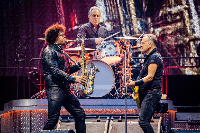 Jake Clemons plays his saxophone on stage with Bruce Springsteen