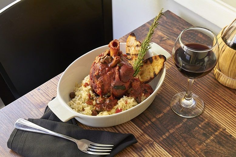 The osso buco di maile (pork shank) and a glass of red wine at Vidalia in Lawrenceville