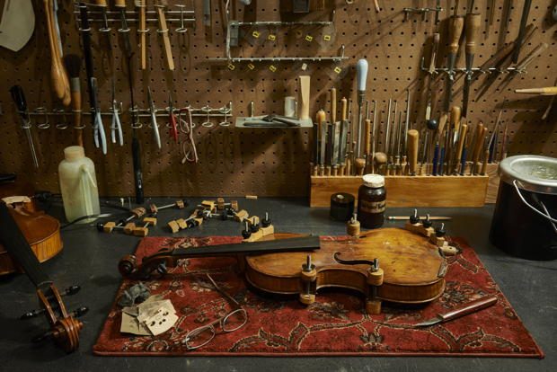 A treasured instrument is glued and clamped at Menzel Violins in Livingston.