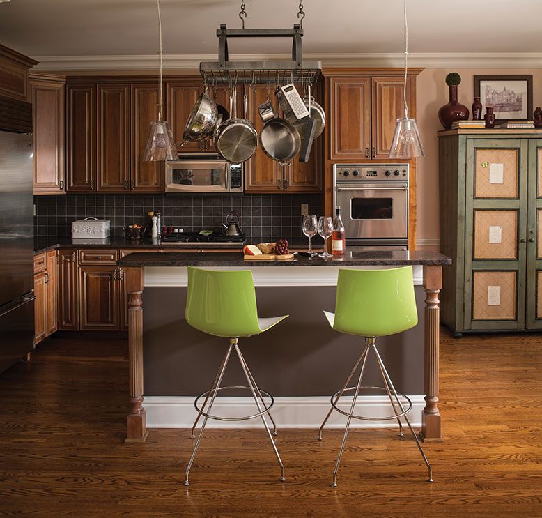 In the kitchen, a pot rack frees up valuable cabinet space. The green stools add a pop of color.