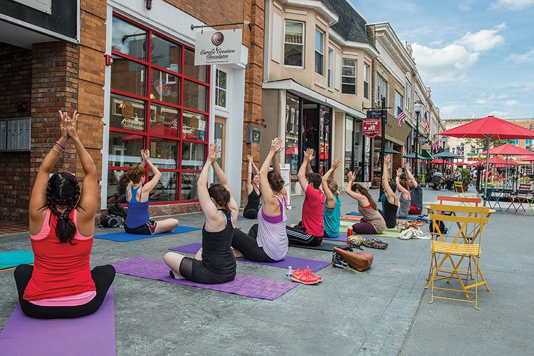 The Division Street pedestrian plaza in Somerville hosts a farmers' market and gatherings like this yoga class.