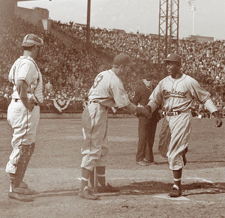 George "Shotgun" Shuba greets Jackie Robinson at the plate after Robinson smashed his first professional home run. Shuba, an Ohio native, would play alongside Robinson in three World Series with the Brooklyn Dodgers.