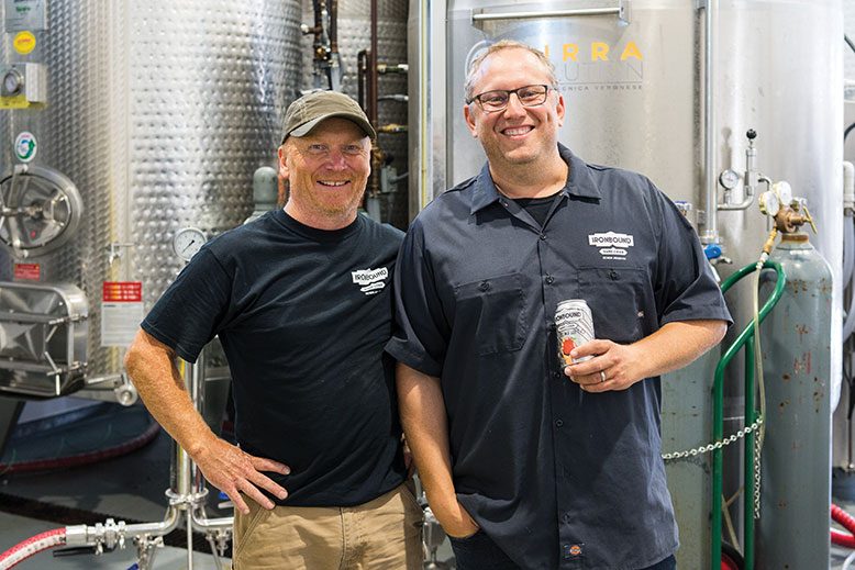At New Ark Farms in Asbury, Ironbound's cider maker, Cameron Stark, left, and Ironbound founder and CEO Charles Rosen flaunt can-do smiles–and a can.