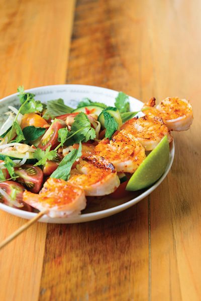 Skewered, grilled shrimp with tomato and cucumber salad.