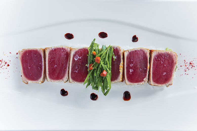 Seared ahi tuna, sprinkled with Maldon sea salt and topped with julienned snowpeas and spiced macadamias. Hidden beneath the tuna is the coconut jasmine rice that completes the dish.