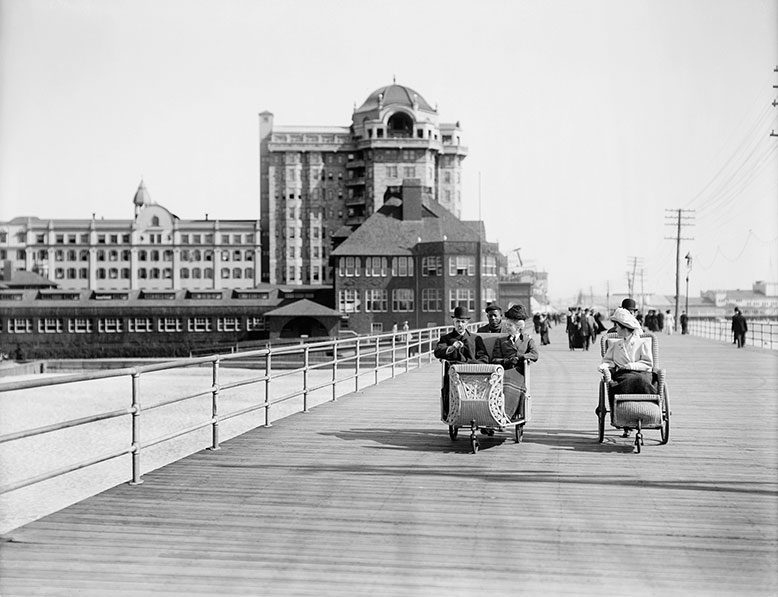 ATLANTIC CITY (1900) Vacationers in roller chairs travel the Boardwalk.